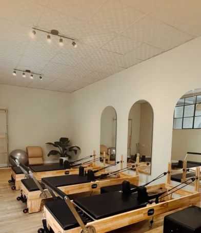 Salón de Pilates con reformers de madera